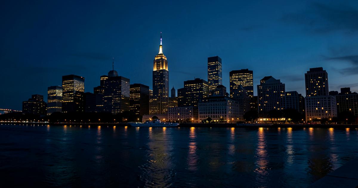 Evening city skyline with lit office towers reflected in the water